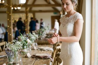 Jeune mariée en robe en dentelle ajuste un bracelet de perles